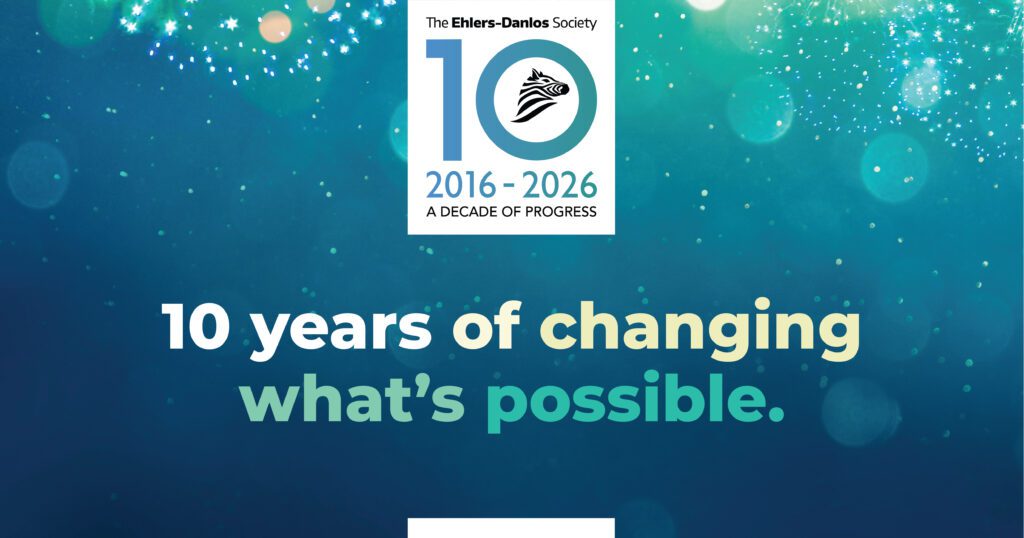 Banner promocional que celebra el décimo aniversario de la Sociedad Ehlers-Danlos. En la parte superior se encuentra el logotipo de la Sociedad Ehlers-Danlos con un "10" y el texto "2016-2026: Una década de progreso". Un texto grande centrado dice "10 años cambiando lo posible". El fondo es un degradado de azul a verde azulado con una suave luz brillante y destellos, creando un tono esperanzador y festivo.